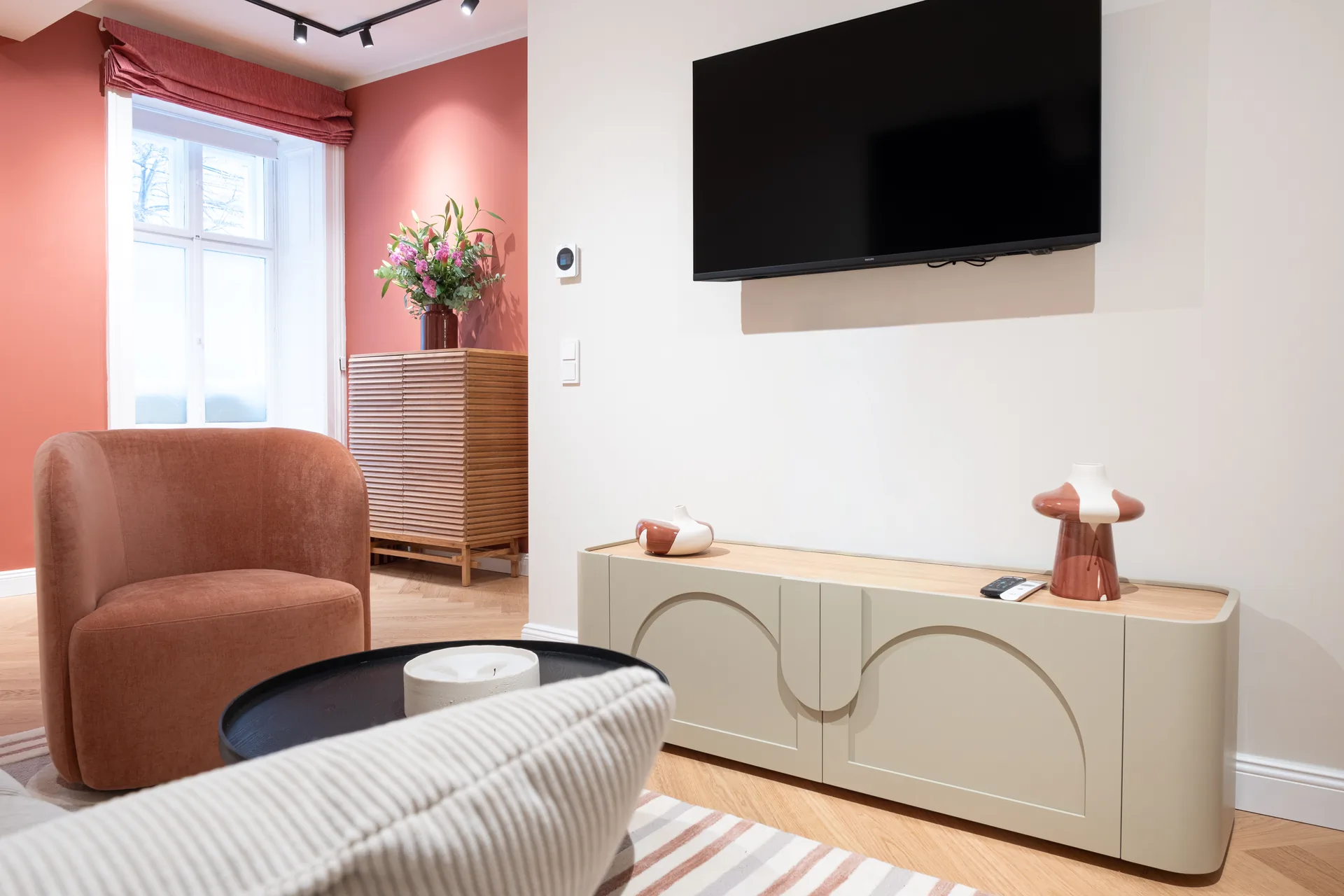 MINT Artisan — living room with terracotta wall and arch TV console